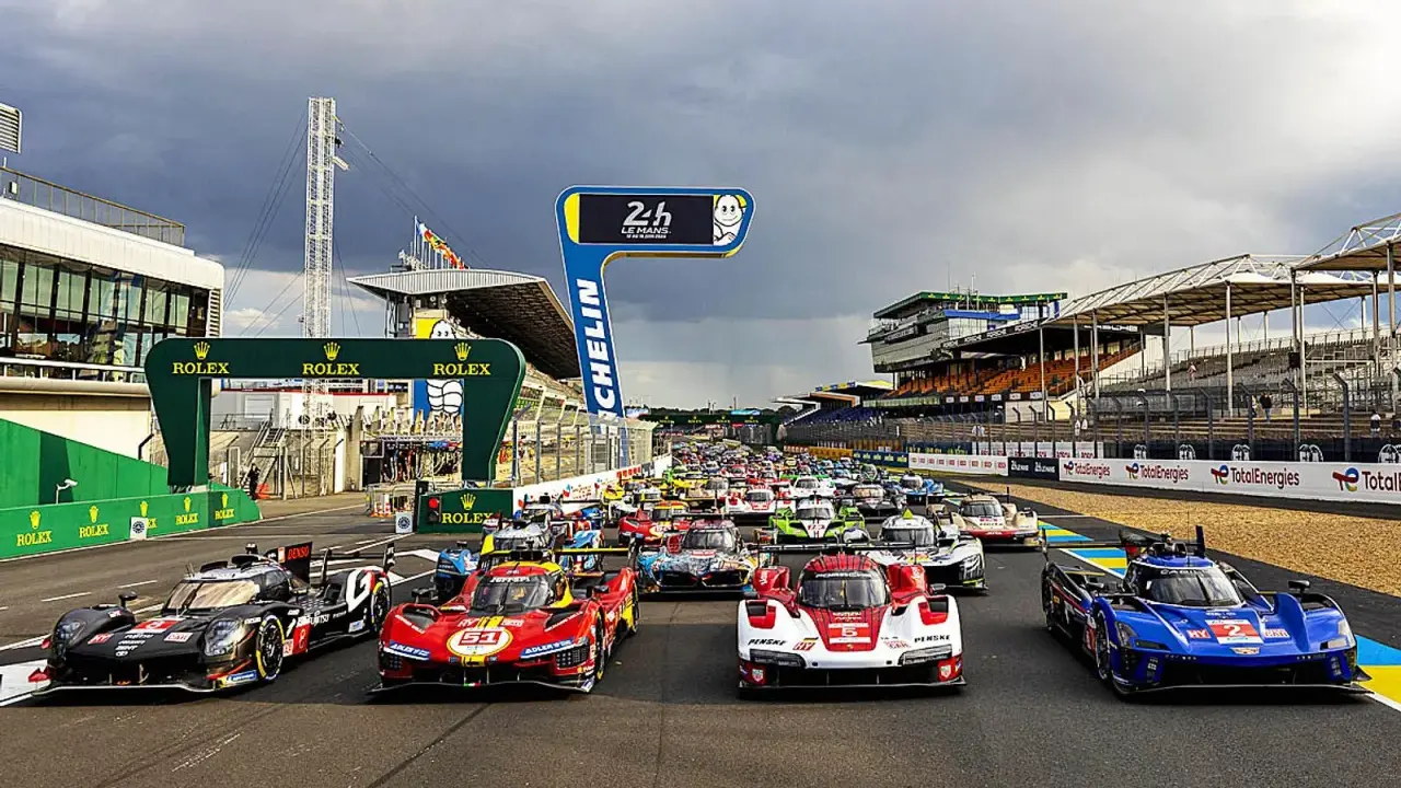 Startaufstellung für das 24-Stunden-Rennen von Le Mans. Rennwagen stehen bereit, die Spannung ist greifbar.