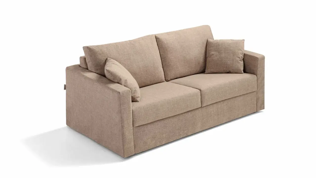 En beige soffa med lösa kuddar, perfekt för den som vill byta stoppning soffa och ge den nytt liv.