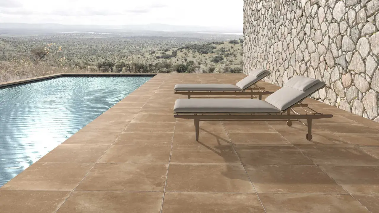 Elegante suelo para piscinas de tonos tierra, con tumbonas y vistas a un paisaje natural.