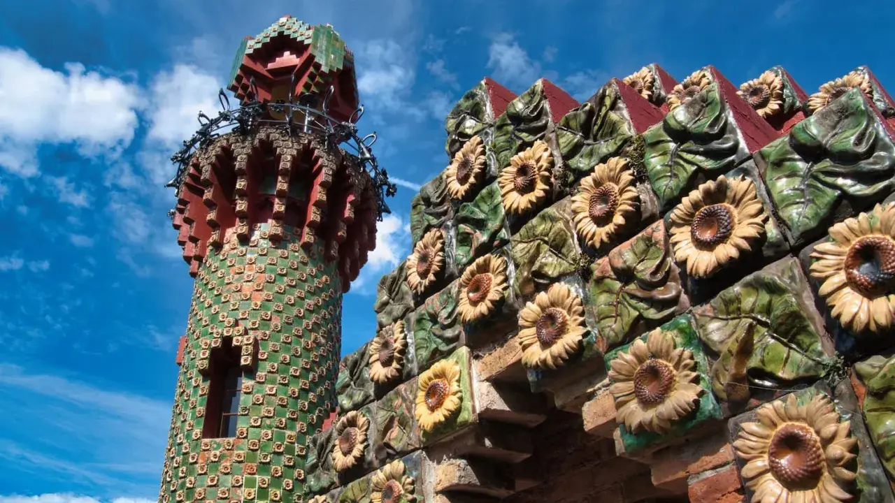 Bunte Sonnenblumen zieren die Fassade eines Turms in Comillas, Spanien.