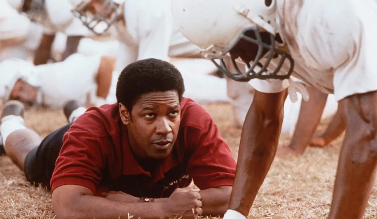 Denzel Washington, allenatore in un film sportivo, ispira la sua squadra. Storie vere di trionfo e determinazione.