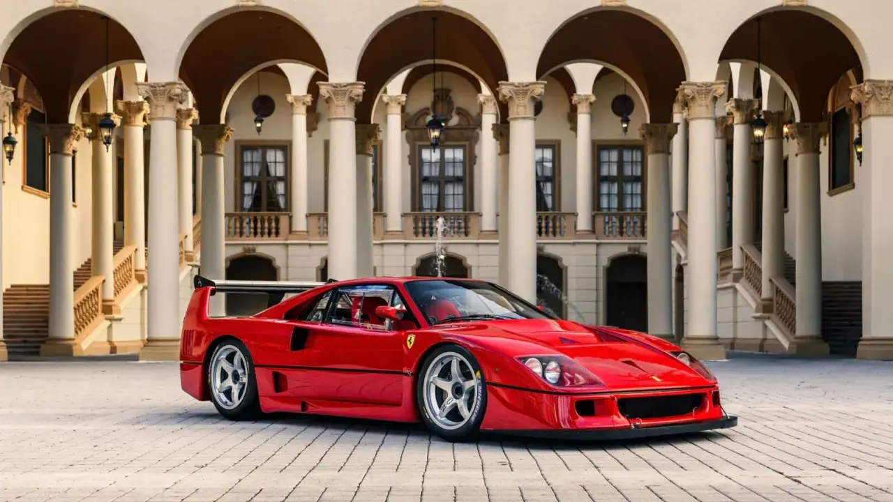 Ein roter Ferrari F40 steht vor einer prächtigen Villa mit Säulengängen.