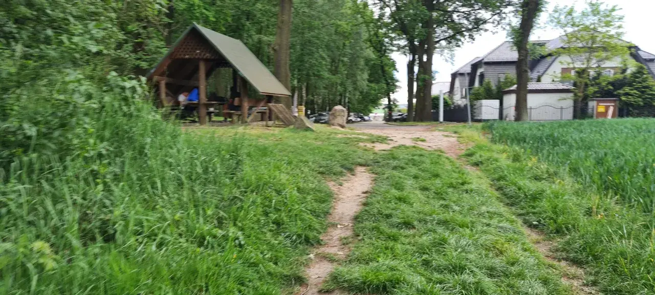 Ścieżka wśród zieleni prowadzi do altany, idealnej na odpoczynek po przejażdżce po trasach rowerowych Ruda Śląska.