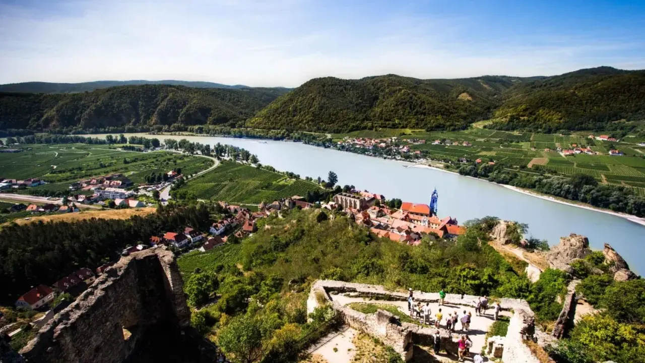 Widok na malowniczą dolinę Wachau z ruinami zamku, rzeką Dunaj i winnicami.