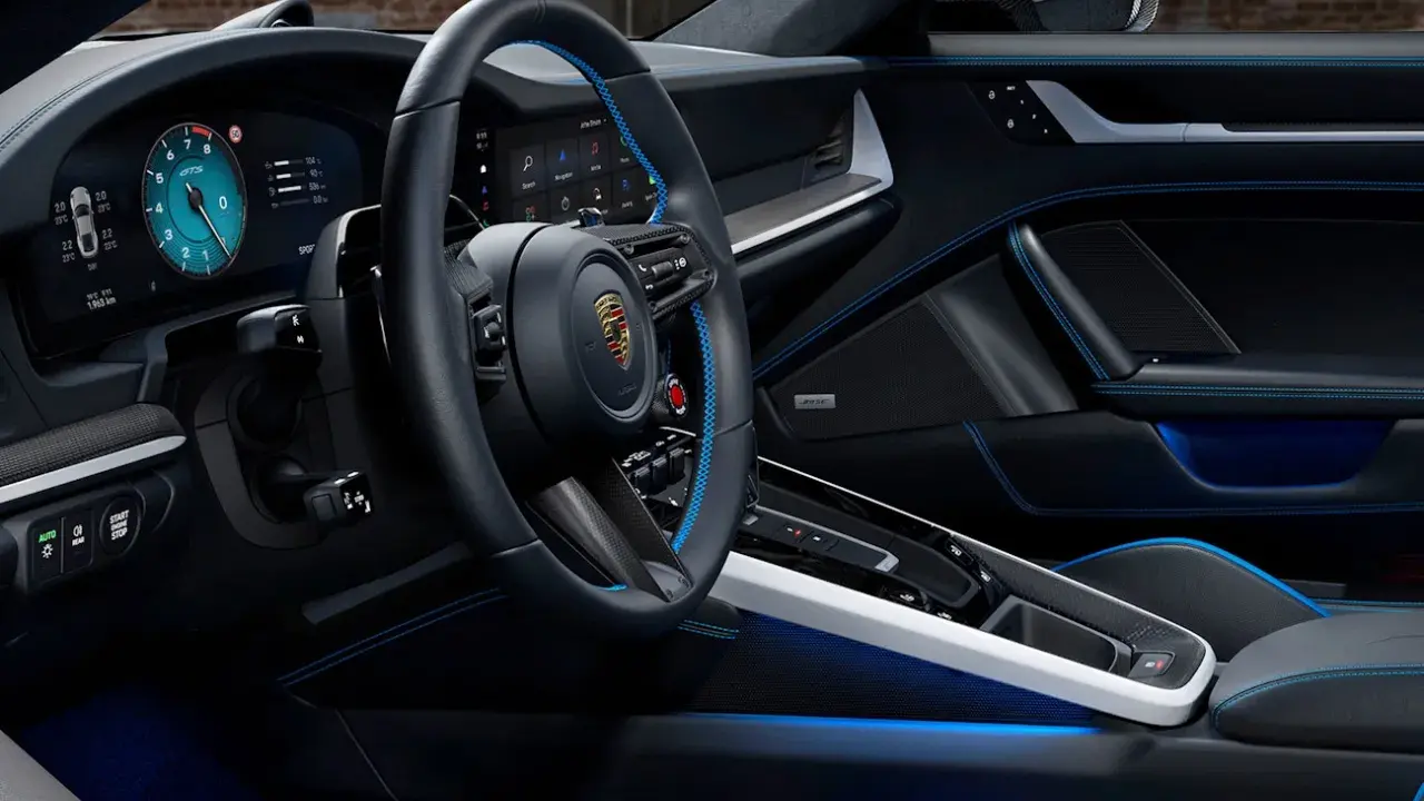 Der porsche 911 innenraum mit blauen Akzenten und digitalem Cockpit. Luxuriöses Leder und Carbon-Details.