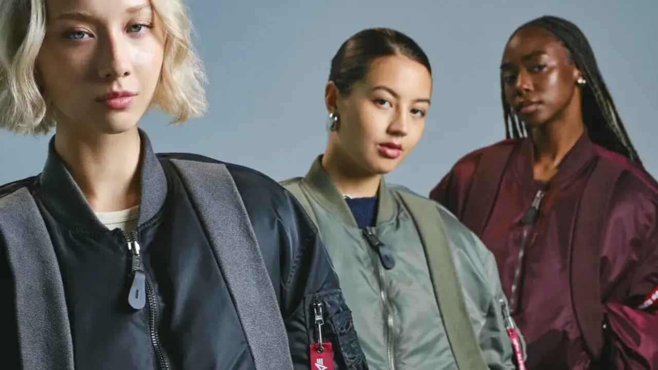 Trzy kobiety w kurtkach bomberkach Alpha Industries. To znana marka odzieży lotniczej.