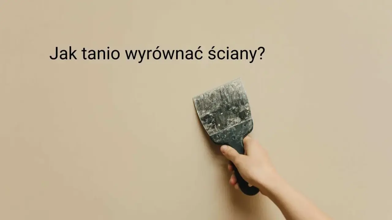 Ręka trzyma szpachelkę przy beżowej ścianie, szukając pomysłu na krzywe ściany.