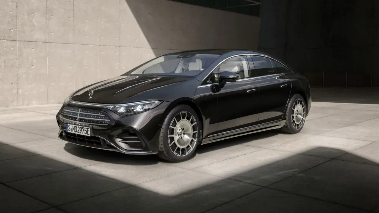 Schwarzer Mercedes-Benz EQS mit Facelift-Design, elegant vor Betonwand.