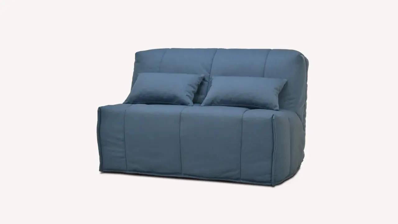Canapé convertible bleu, deux coussins. Facile à transformer en lit, découvrez comment replier un bz pour gagner de la place.