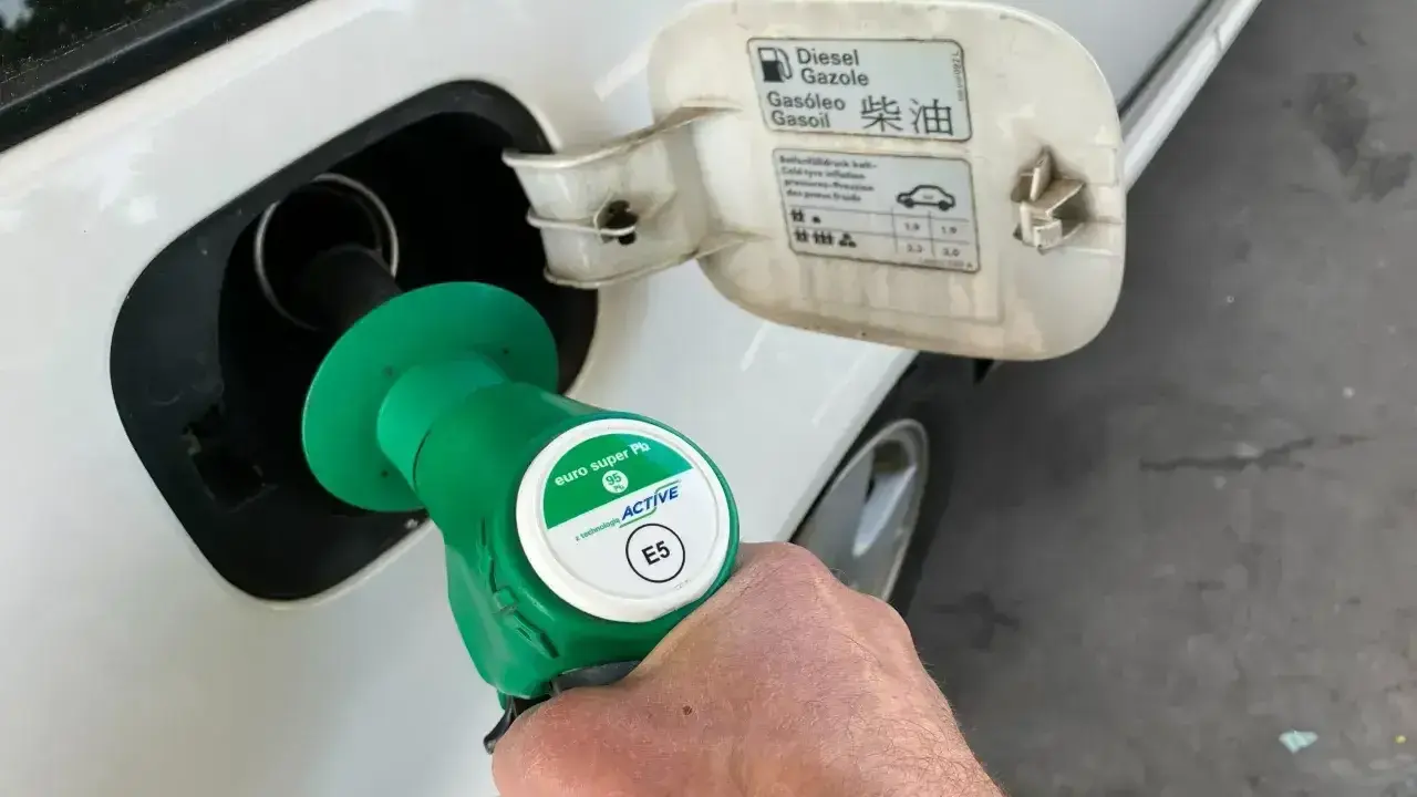 Tankowanie auta. Pistolet z zieloną końcówką, oznaczony jako "euro super Pb E5", jest wkładany do wlewu paliwa. Na klapce wlewu widnieje napis "Diesel".