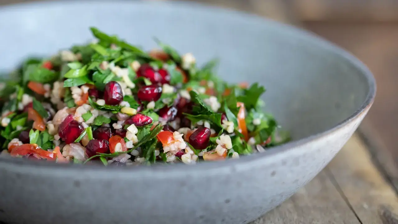 Frischer Tabouleh-Salat mit Granatapfelkernen, Petersilie und Bulgur. Ein köstliches tabouleh rezept für den Sommer.