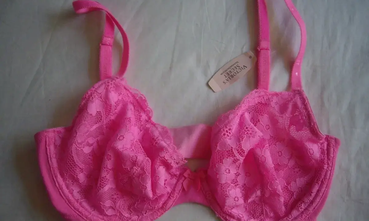 Reggiseno rosa acceso con pizzo floreale, spalline regolabili e un piccolo fiocco al centro. Taglia coppa DD.