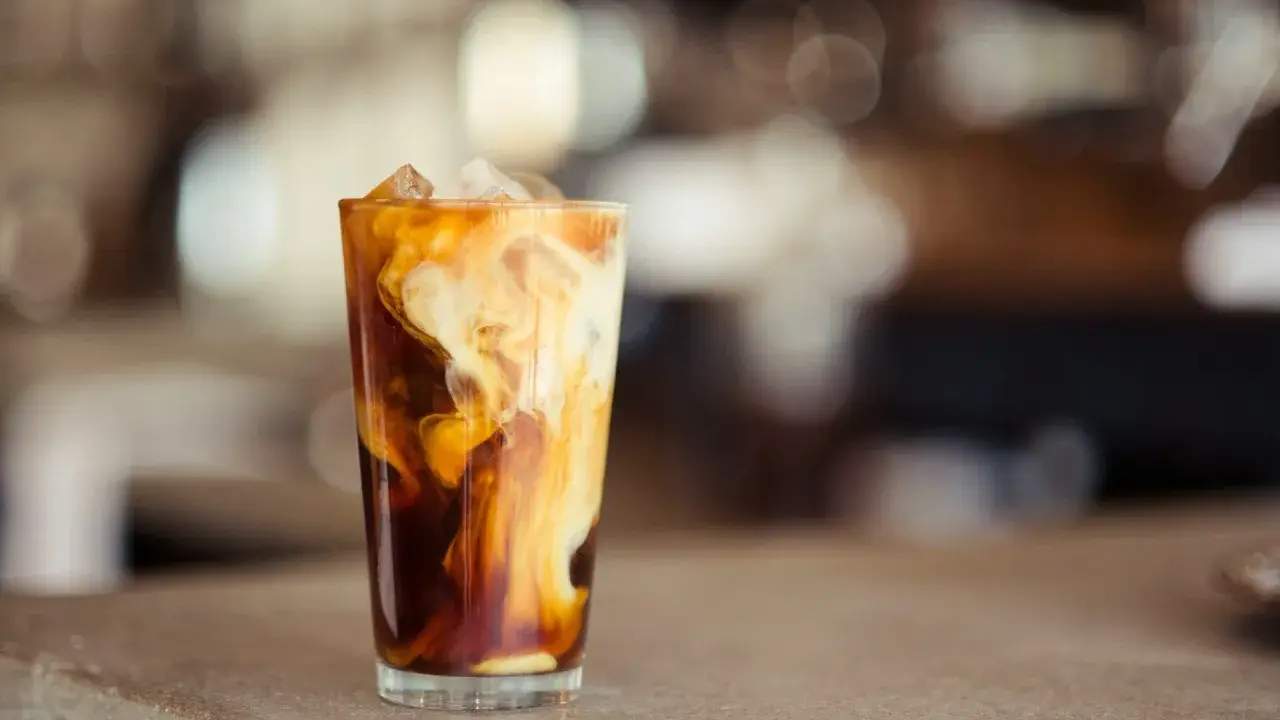 Ein Glas Eiskaffee mit cremigen Wirbeln von Baileys, perfekt für einen entspannten Nachmittag.