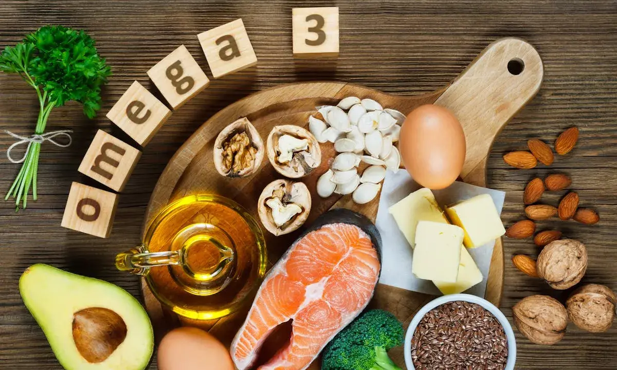 Assortiment d'aliments riches en oméga 3 : saumon, noix, avocat, œufs, huile, graines de lin, amandes, brocolis et beurre.