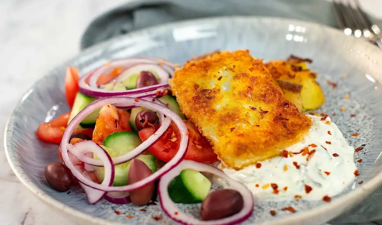 Krispigt panerad fisk med grekisk sallad och tzatziki. Ett perfekt fetaost recept för en lätt lunch.