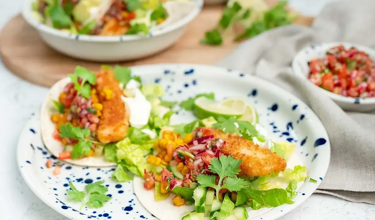 Två läckra fish tacos med krispig fisk, färsk salsa, majs och grönsaker. En festlig måltid!
