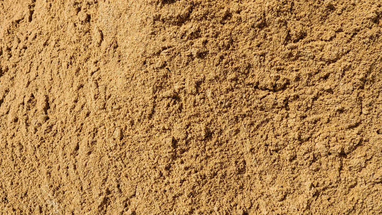 Textura de arena de miga, ideal para construcción, jardinería y filtración. Sus usos son variados y esenciales.