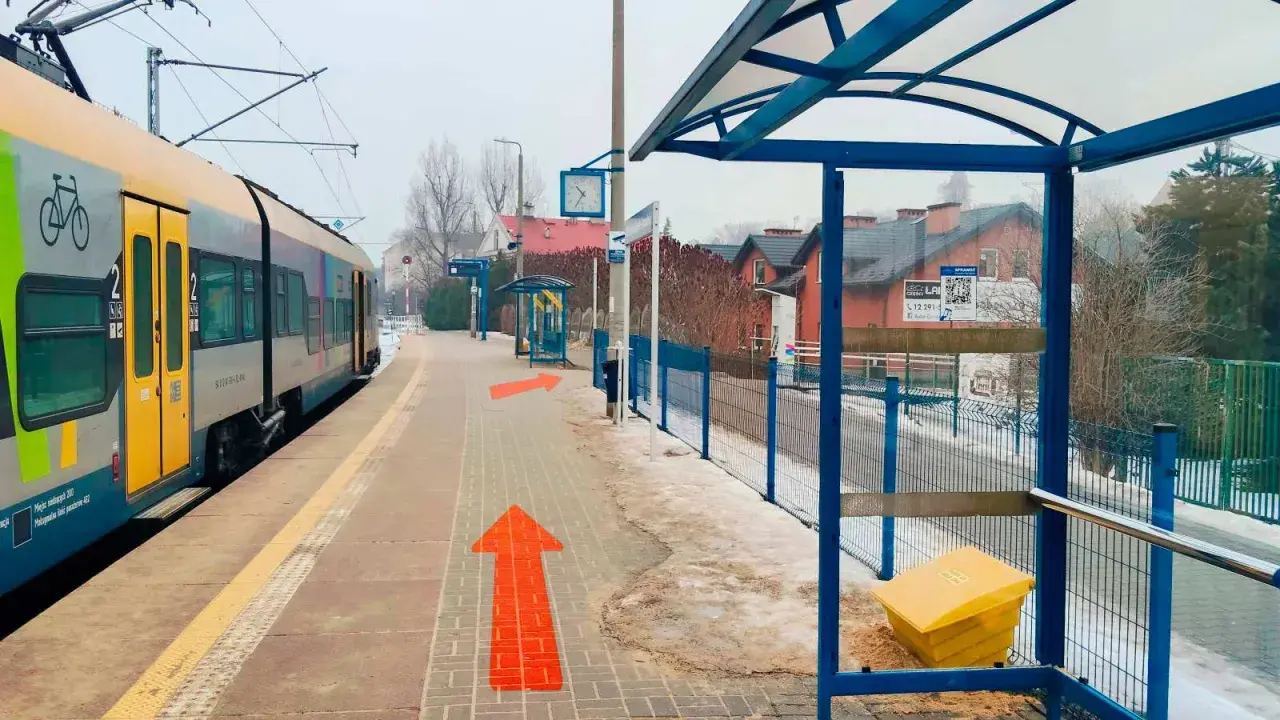Pociąg na stacji, strzałki wskazują drogę. Tak jak dojechać z Krakowa do Wieliczki.