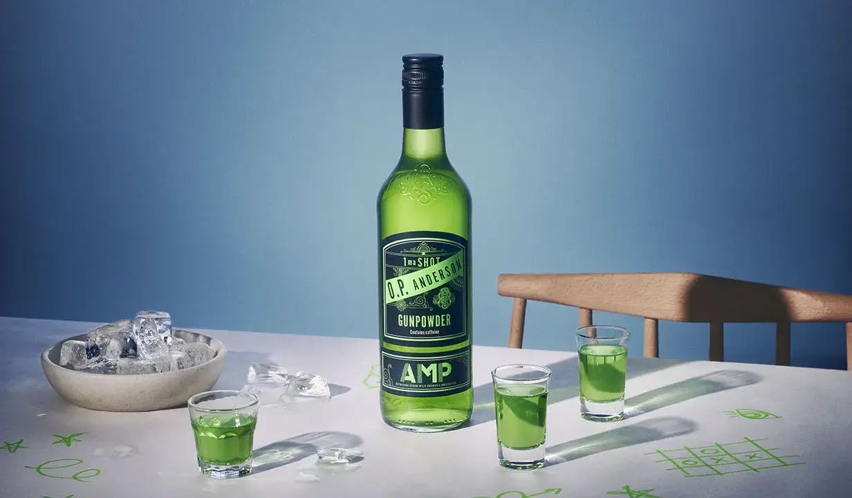 O.P. Anderson Gunpowder i gröna shotglas på ett bord med is och tic-tac-toe-ritningar.