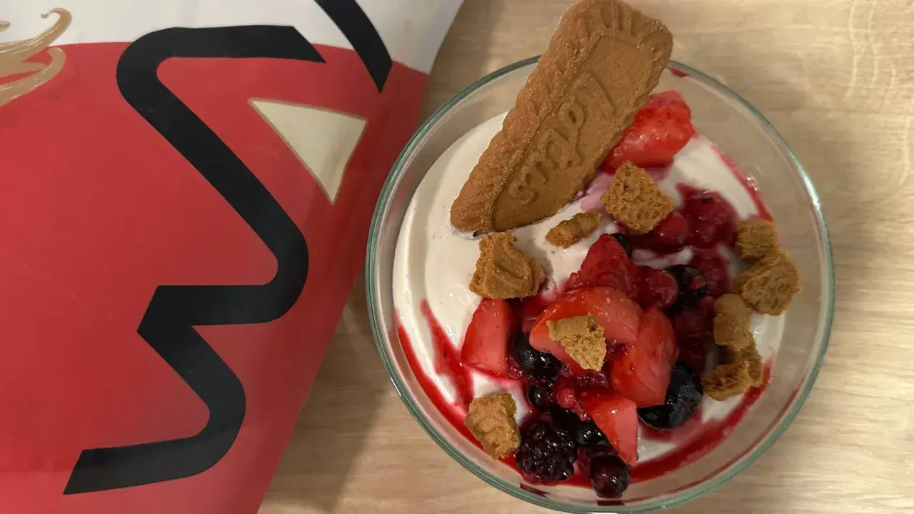 Leckere vegane Smoothie Bowl mit frischen Beeren, Kekskrümeln und einem Lotus-Keks.
