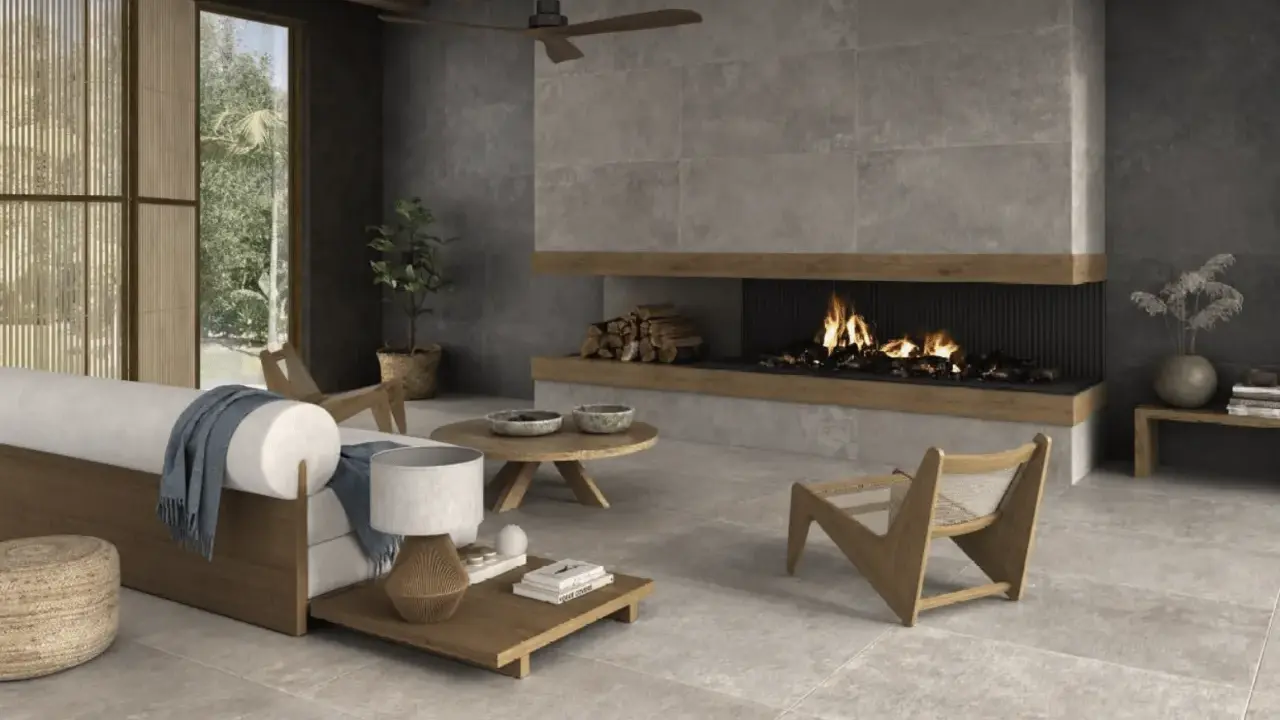 Salón moderno con chimenea encendida, sofá blanco y suelo de cemento pulido.