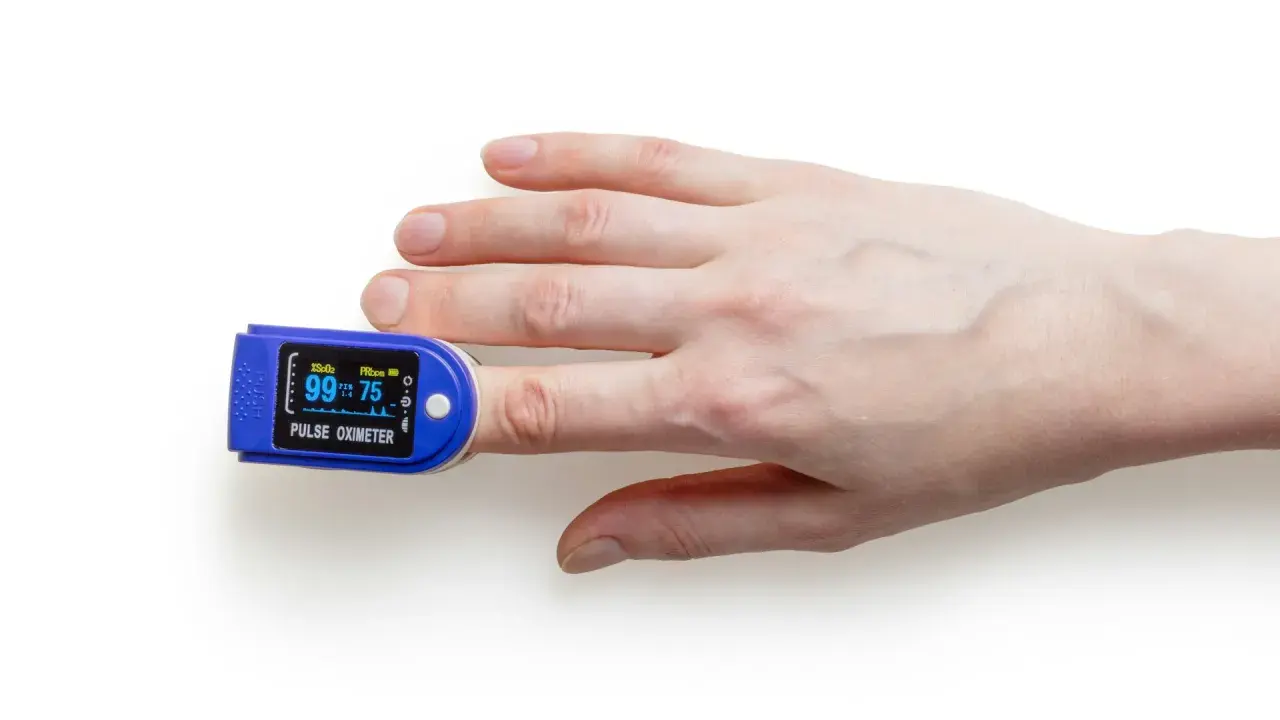 Fingerspitze mit Pulsoximeter, das den Puls beim Spazieren misst.