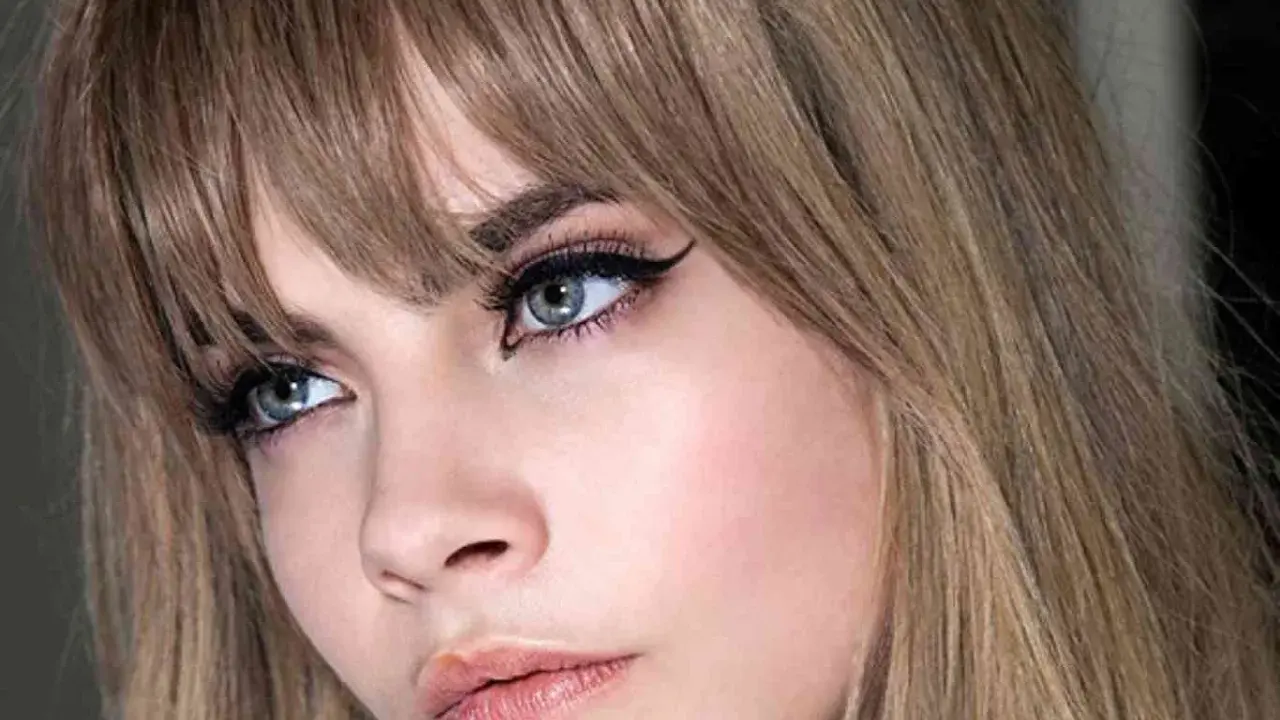Primer plano de una mujer con flequillo rubio desfilado, delineado de ojos dramático y labios rosados. Muestra varios tipos de flequillo.