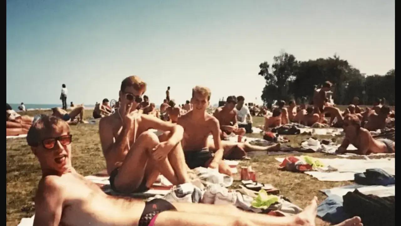 A group of men relax on the grass at a gay beach in Chicago.