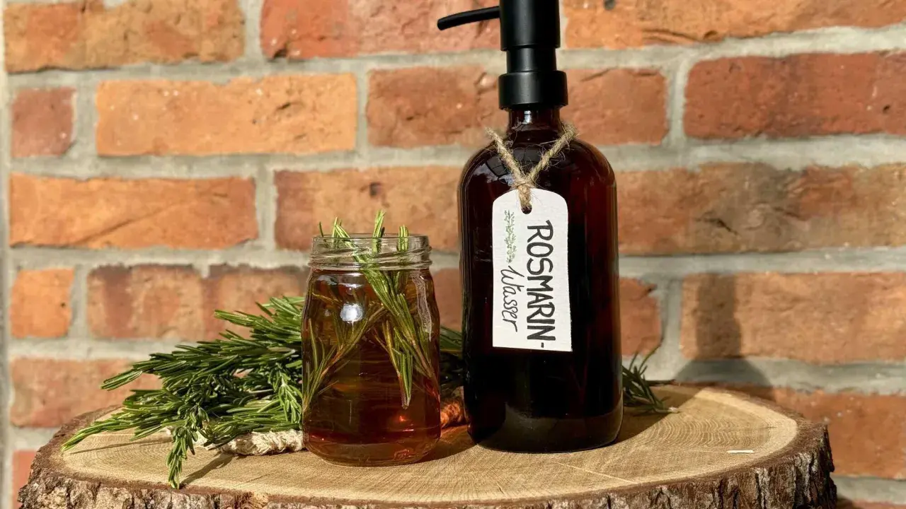 Zutaten für Rosmarinwasser Haare selber machen: frischer Rosmarin, ein Glas mit Flüssigkeit und eine dunkle Flasche mit Pumpspender.