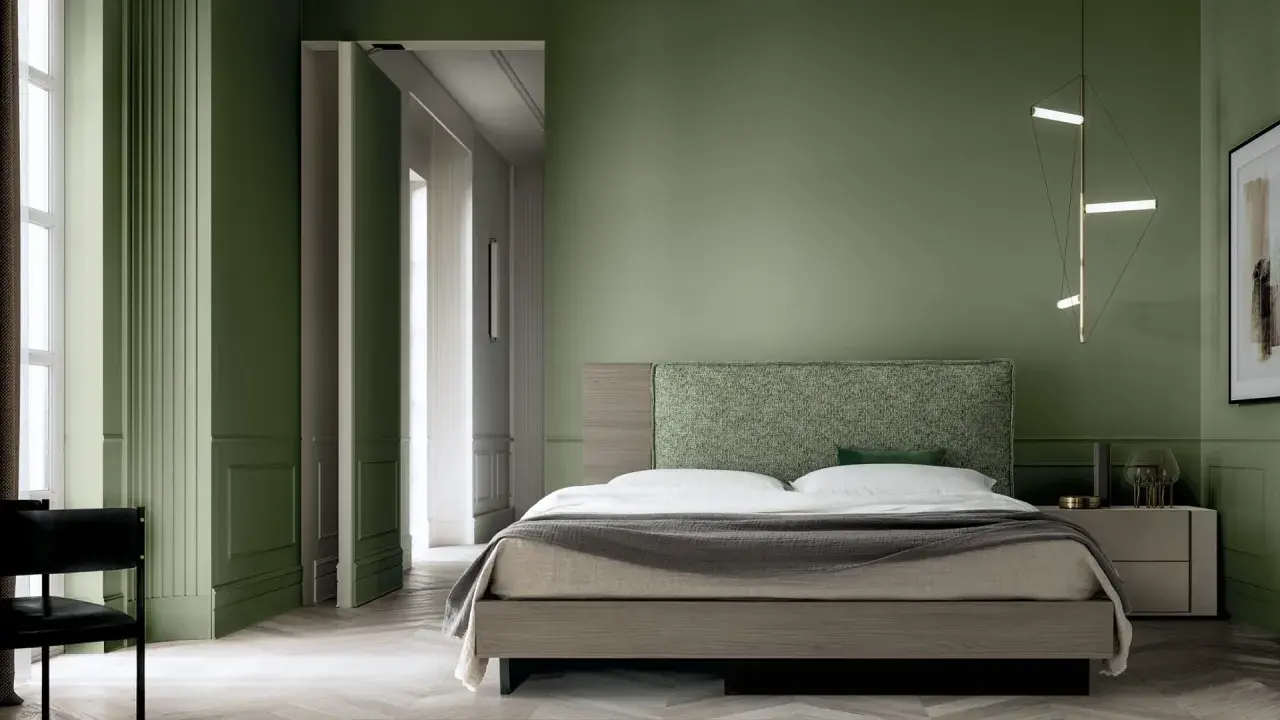 Camera da letto con pareti verde bosco, letto moderno con testiera tessuta e lampada geometrica.