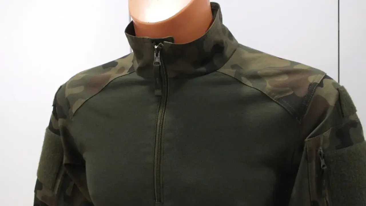 Zielona bluza combat z kamuflażem na ramionach i rękawach. Zapinana na zamek.