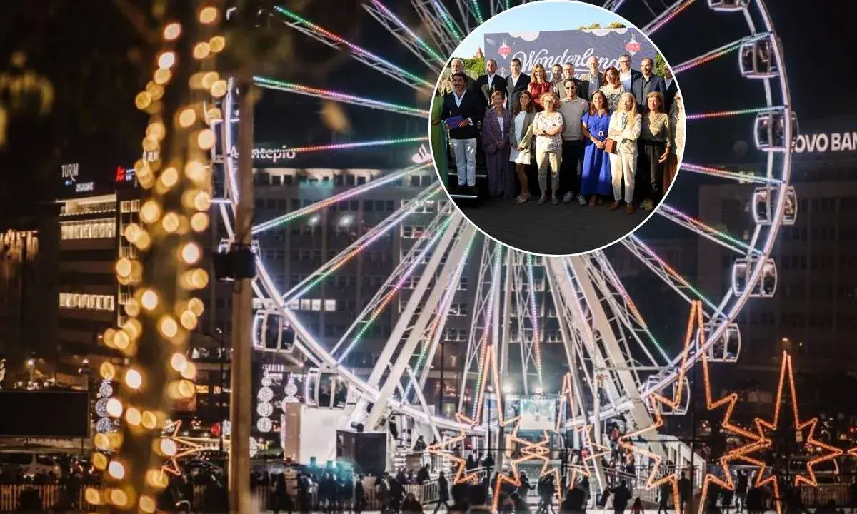 Eine Gruppe feiert bei Wonderland Lisboa vor einem beleuchteten Riesenrad.