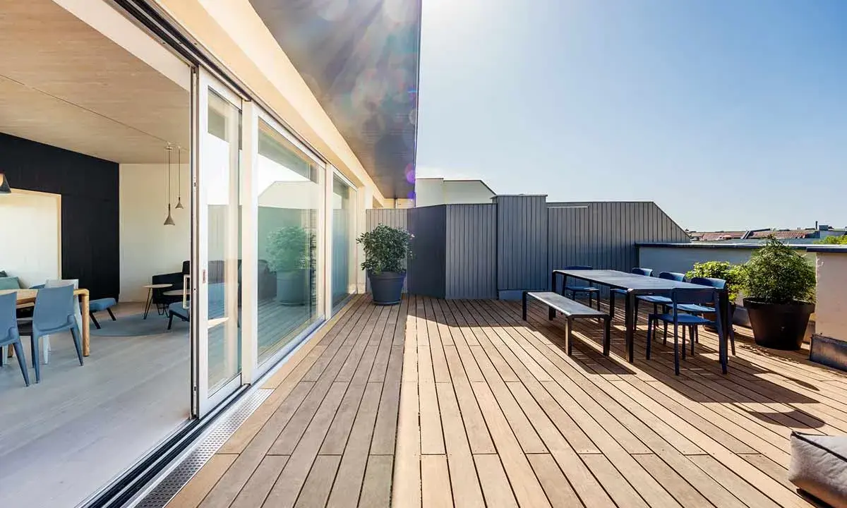 Modernes Einfamilienhaus mit großzügiger dachterrasse. Holzboden, Sitzgruppe und Pflanzen laden zum Verweilen ein.