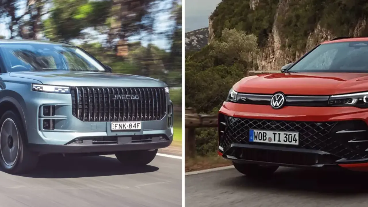 Dwa SUV-y na drodze: szary z pionową atrapą i czerwony Volkswagen SUV z charakterystycznym logo.