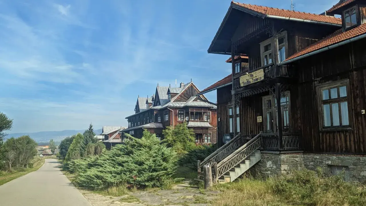 Drewniane wille w osadzie Czorsztyn, z charakterystyczną architekturą i zielenią, zapraszają do podróży w czasie.