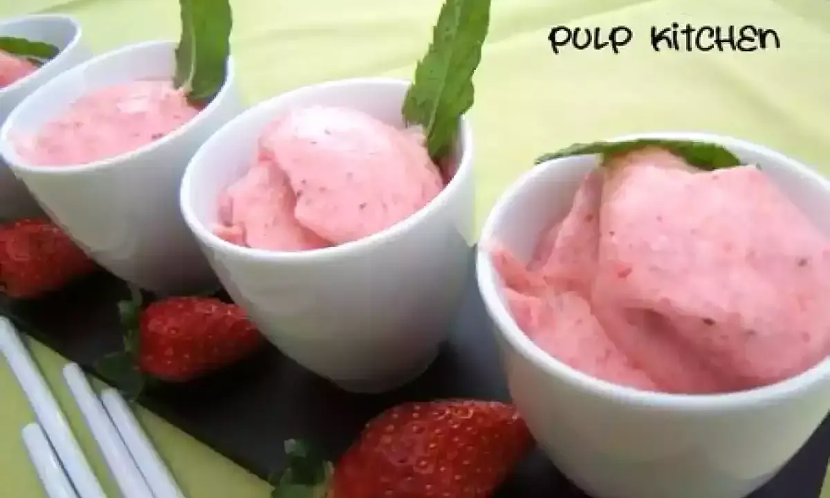 Délicieuse mousse fraise dans des coupelles blanches, garnie de menthe. Fraises fraîches et bâtonnets complètent cette gourmandise.