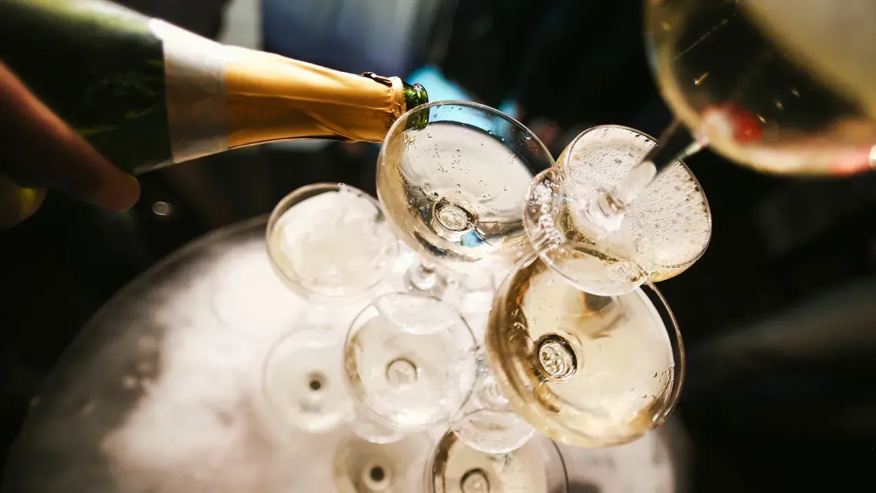 Champagner wird in Gläser gegossen, ein Moment, der die Champagner Geschichte feiert.