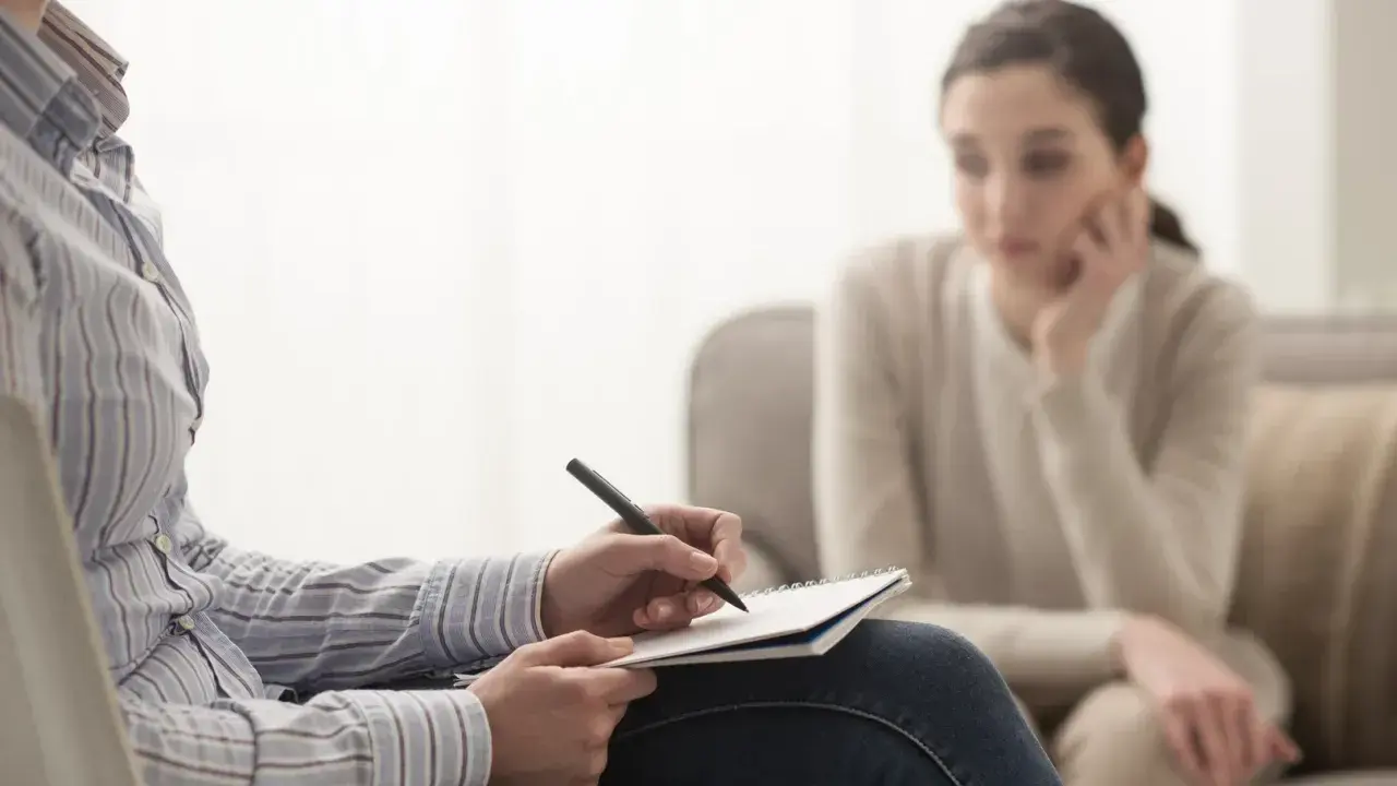 Psycholog kliniczny notuje podczas sesji. Zastanawiasz się, ile zarabia psycholog kliniczny prywatnie?