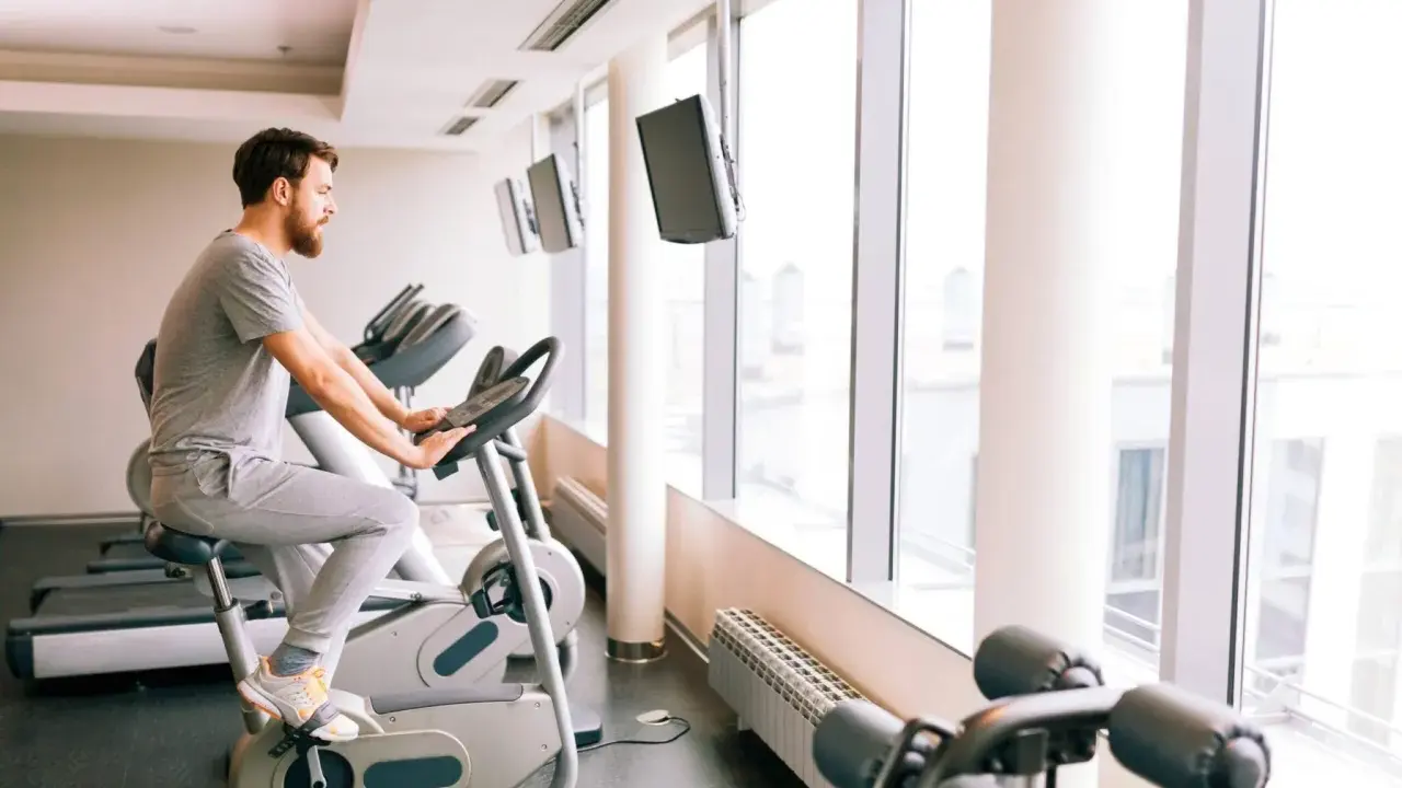 Mężczyzna ćwiczy na rowerze stacjonarnym, który może być dobrym wyborem, jeśli zastanawiasz się, jaki rower stacjonarny do rehabilitacji kolana.
