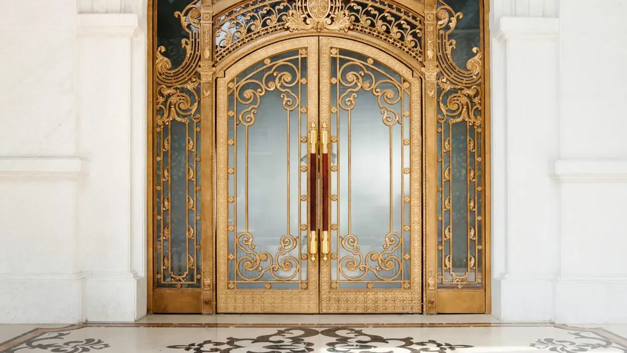 Prunkvolle goldene Doppeltür im **Art déco Baustil** mit filigranen Verzierungen und Marmorboden.