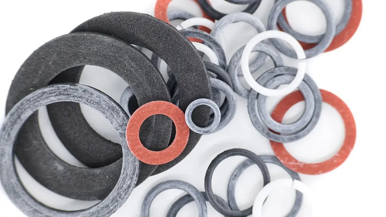 Gros plan sur un assortiment de joints toriques plats de différentes tailles et couleurs (noir, gris, blanc, rouge), prêts à sceller.