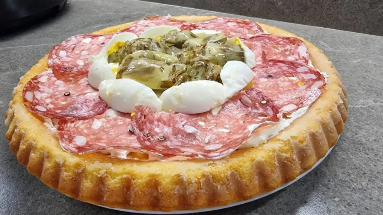 Crostata morbida salata con salame, uova sode e carciofini sott'olio, un'idea gustosa per un aperitivo o un antipasto.