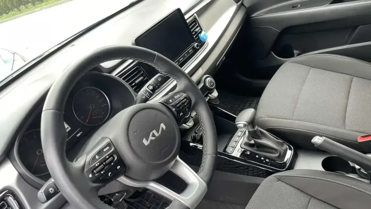 Wnętrze samochodu z automatyczną skrzynią biegów. Widoczna kierownica, deska rozdzielcza i dźwignia zmiany biegów. Idealne do zdobycia prawo jazdy na automat oznaczenie.