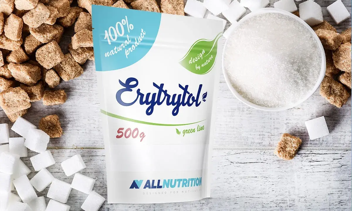 Erytrytol obok kostek cukru i miseczki z kryształkami. Naturalny słodzik, zdrowsza alternatywa dla cukru.