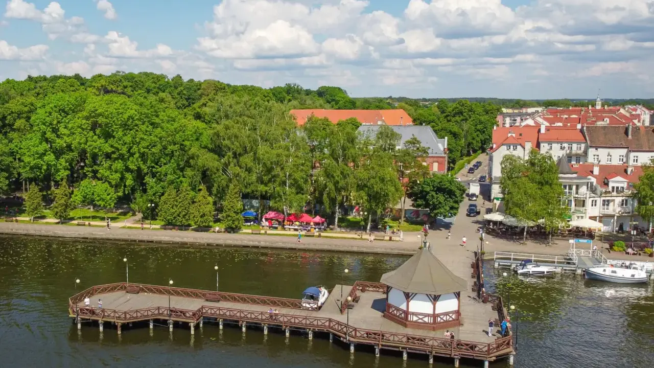 Malownicze Mazury: molo, urokliwe miasteczko i zielone drzewa. Idealne miejsce, gdzie najlepiej na Mazury.