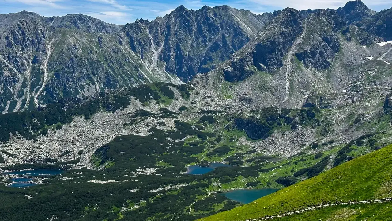 Tatry widziane z trasy turystycznej. Jeziora w dolinie, skaliste zbocza i zielone hale zachęcają do odkrywania piękna Zakopanego.