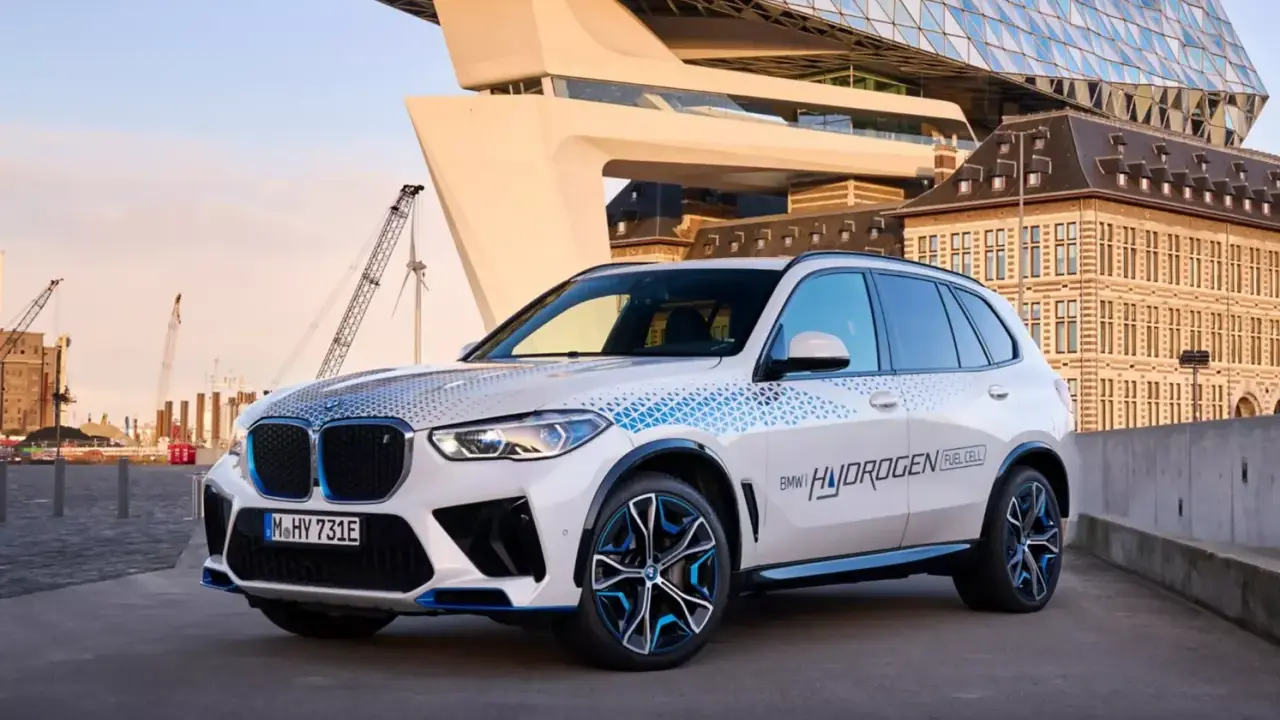 BMW iX5 Hydrogen, ein Vorreiter unter den BMW Elektro Modellen, mit futuristischer Architektur im Hintergrund.