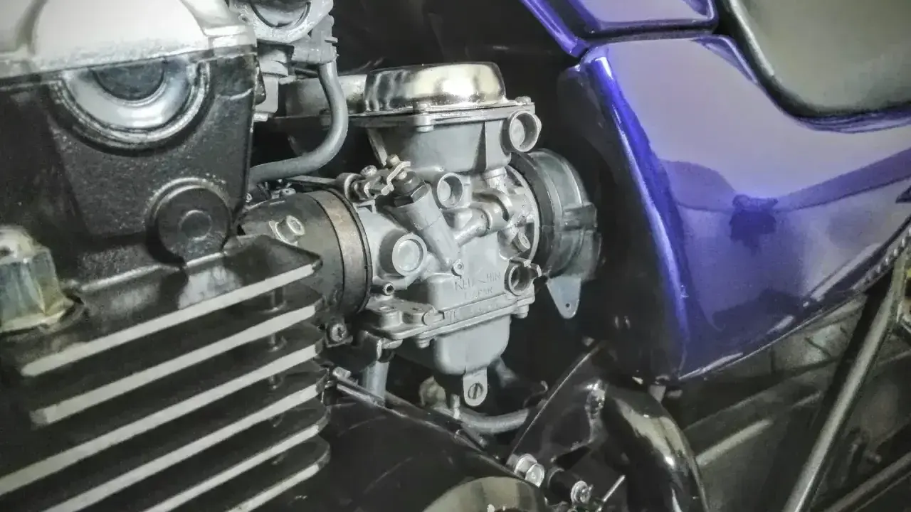 Silnik motocykla z gaźnikiem i fioletowym bakiem. Gotowy do dolotu i dalszej jazdy.