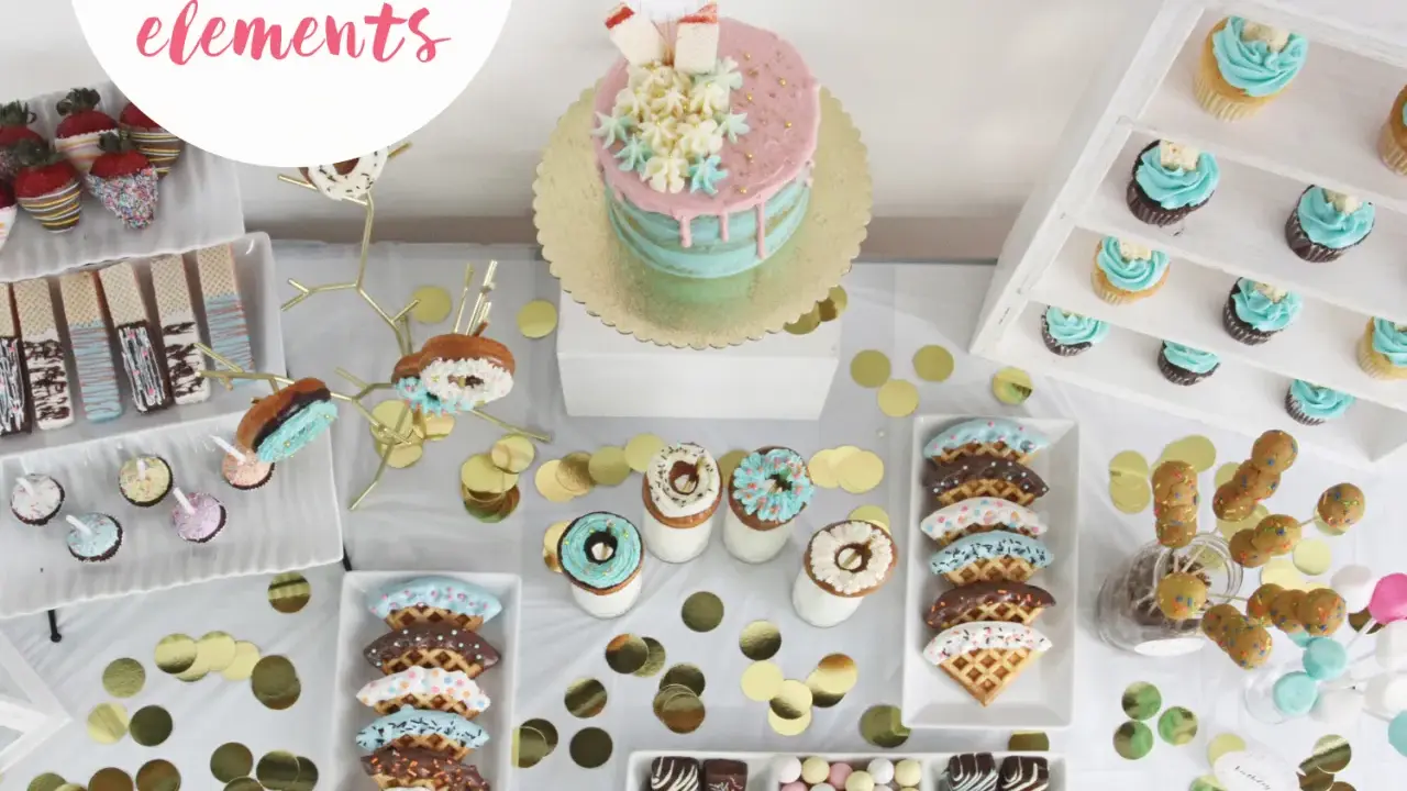 Ideas para decorar un candy bar: mesa dulce con pastel, cupcakes, donas, fresas cubiertas, galletas y confeti dorado.