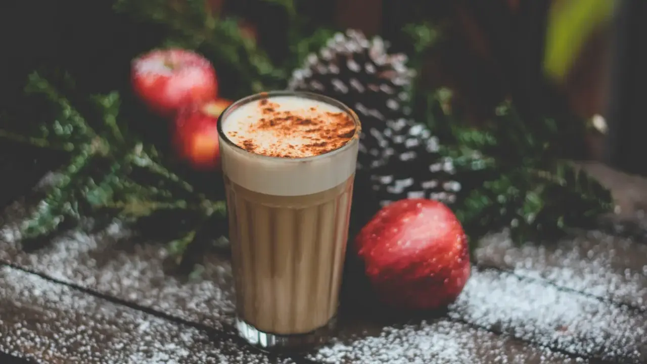 En krämig kaffedrink med kanel, omgiven av juliga äpplen och granris. Perfekt för mysiga stunder och inspirerar till egna kaffedrinkar recept.